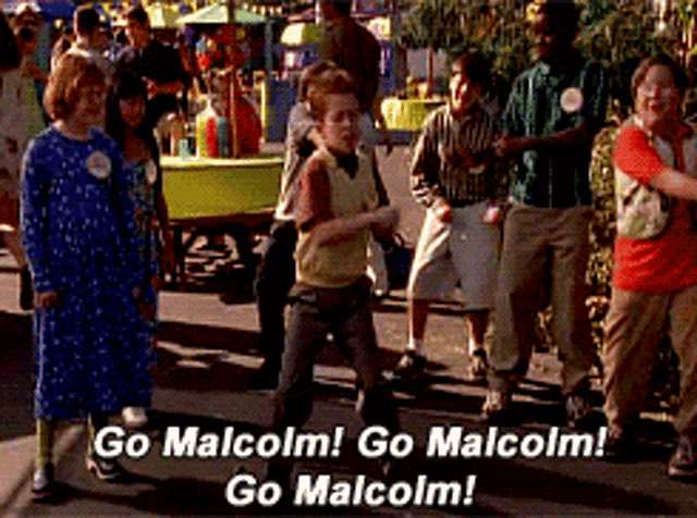 a group of people walking down a street with the words go malcolm go malcolm go malcolm